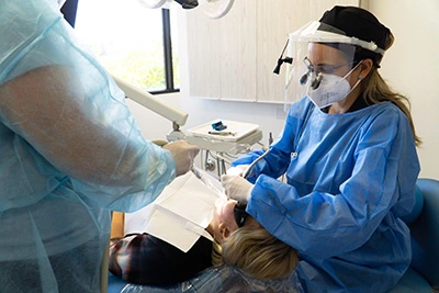 Dr. Barrera and her hygienist working on a patient's teeth