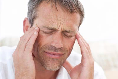man holding his head from TMJ pain