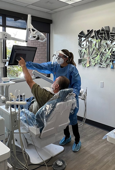 Dentist at Barrera Advanced Dentistry showing patient their x-ray on a screen