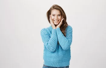 joyful excited brunette in a blue sweater
