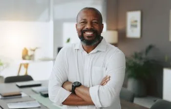 Mature, portrait or black man with arms crossed in office as confident project manager for development. Opportunity, smile or proud entrepreneur in startup company with mission or business commitment